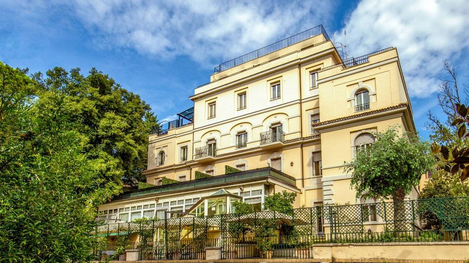 Stilvolles Hotel mit eleganter Fassade in ruhiger Lage, umgeben von viel Grün – idealer Ausgangspunkt für einen komfortablen und erlebnisreichen Urlaub in Italien.
