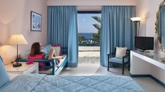 Helles Zimmer mit gemütlicher Sitzecke, großem Bett und traumhaftem Meerblick vom eigenen Balkon – ideal zum Entspannen und Genießen.