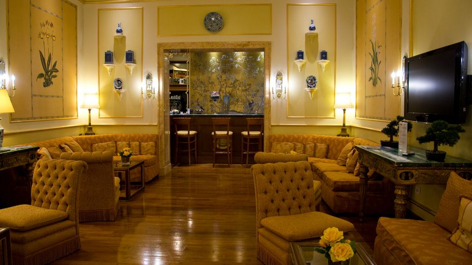Eleganter Hotel-Loungebereich mit stilvollen Sitzgruppen, warmen Farben und klassischem Dekor – einladender Ort zum Entspannen mit gemütlicher Atmosphäre und charmanten Details.