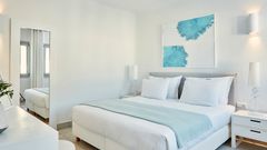 Helles, modern eingerichtetes Doppelzimmer in Weiß- und Blautönen mit gemütlichem Bett, stilvollen Dekoelementen und ruhiger Wohlfühlatmosphäre.
