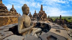 Meditierender Buddha und steinerne Stupas im Tempel von Borobudur