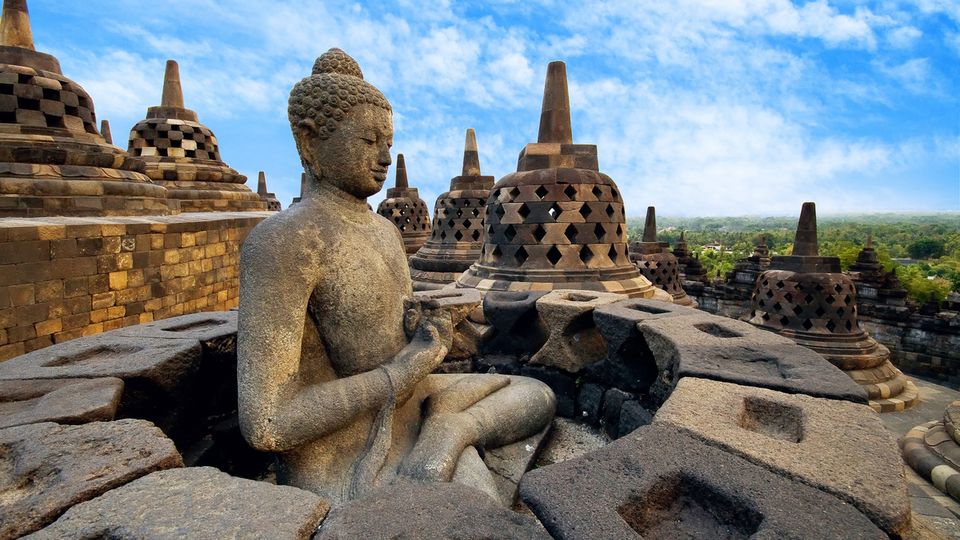 Meditierender Buddha und steinerne Stupas im Tempel von Borobudur