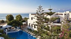 Charmantes Hotel mit mediterranem Flair, eingebettet in eine grüne Gartenanlage mit Pool und Meerblick – ideal für entspannte Urlaubstage in unmittelbarer Strandnähe.