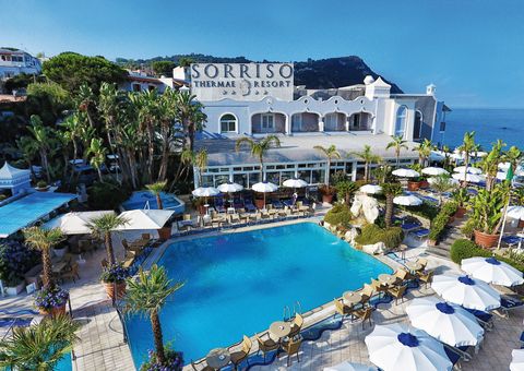 Blick auf Hotel Sorriso Thermae mit Pool und Palmen in Italien, Ischia