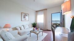 große Sitzecke und Balkon im Zimmer von Hotel Palau auf Sardinien in Italien