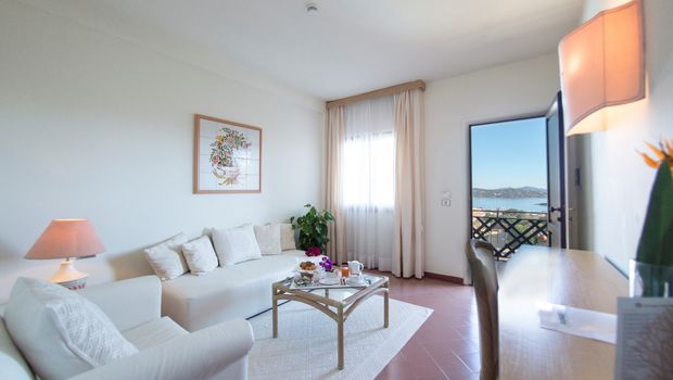 große Sitzecke und Balkon im Zimmer von Hotel Palau auf Sardinien in Italien
