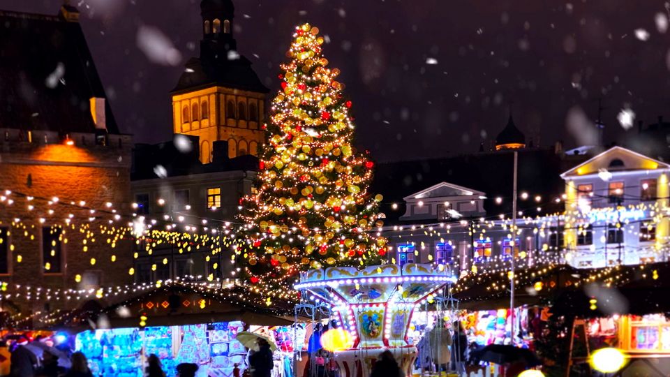 Christmas city market place in Tallinn town Hall Square, Illuminated tree,night light blurred ,people walking ,New year  holiday night celebrating  background travel to Europe 