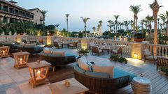 Stimmungsvolle Lounge-Terrasse mit bequemen Sitzmöbeln und Kerzenlaternen – perfekter Ort für einen entspannten Abend mit Blick aufs Meer.