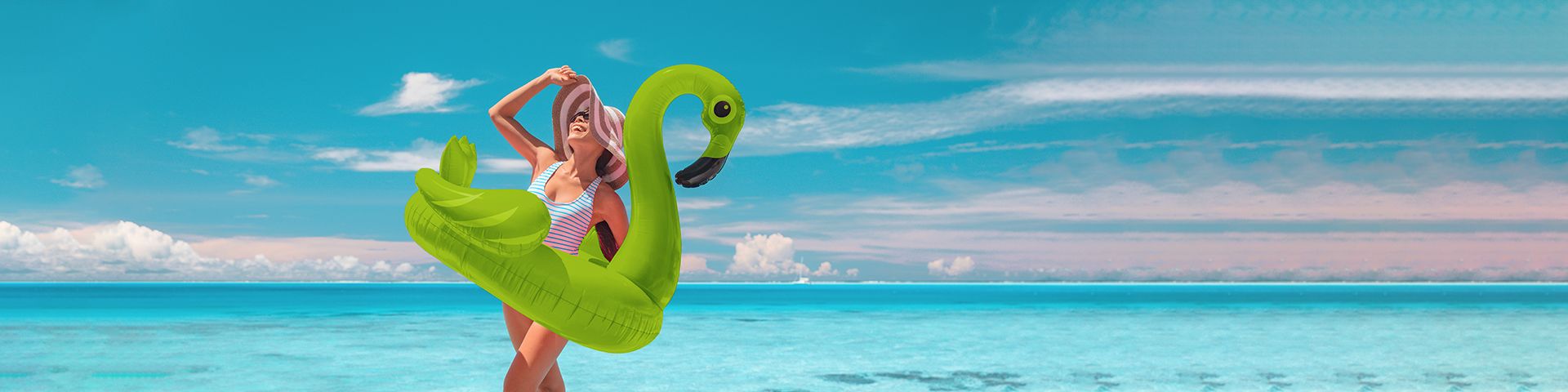Glückliche Frau am Strand mit aufblasbarem Flamingo
