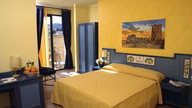 in blauen und gelben Farbtönen eingerichtetes Zimmer im Hotel Dolcestate auf Sizilien in Italien