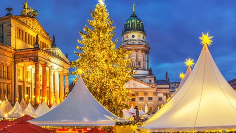 Beleuchteter Weihnachtsmarkt in Berlin mit Blick auf Französischen Dom und Konzerthaus