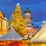 Beleuchteter Weihnachtsmarkt in Berlin mit Blick auf Französischen Dom und Konzerthaus
