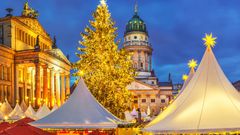 Beleuchteter Weihnachtsmarkt in Berlin mit Blick auf Französischen Dom und Konzerthaus