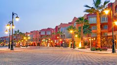 Hafenpromenade Hurghada mit Palmen vor den Gebäuden und leuchtenden Laternen
