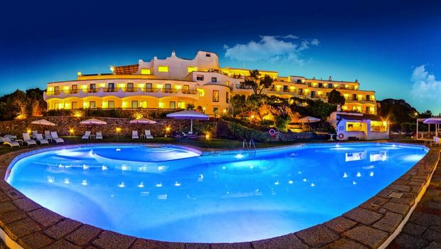 großer beleuchteter Außenpool am Abend im Hotel Luci di la Muntagna auf Sardinien in Italien