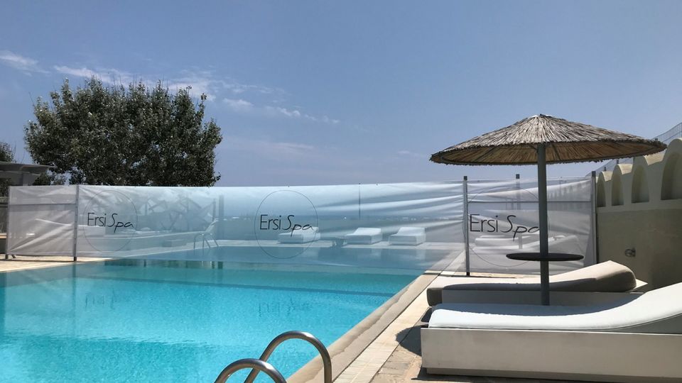 Einladender Außenpool des Ersi Spa mit komfortablen Liegen und Sonnenschirmen – perfekte Kulisse für entspannte Stunden unter der griechischen Sonne.