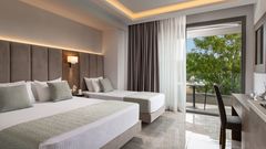Modernes Familienzimmer mit zwei komfortablen Betten, stilvollem Interieur und möbliertem Balkon – perfekt für entspannte Urlaubstage mit der ganzen Familie.