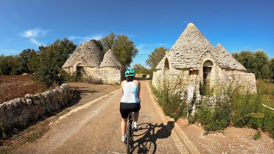 Radfahrerin bei Trulli-Häusern in Apulien
