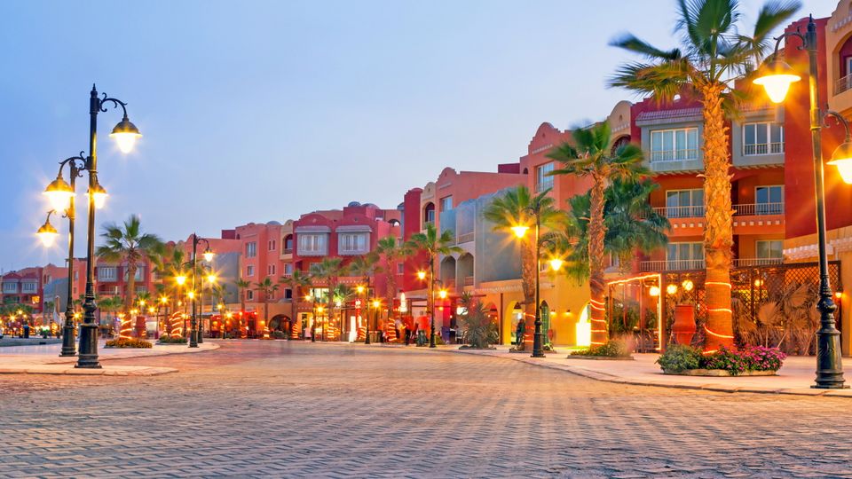 Hafenpromenade Hurghada mit Palmen vor den Gebäuden und leuchtenden Laternen