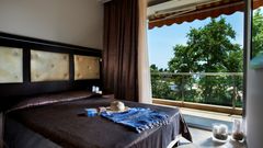 Komfortables Doppelzimmer mit elegantem Design und Zugang zum Balkon – genießen Sie entspannte Stunden mit Blick ins Grüne.